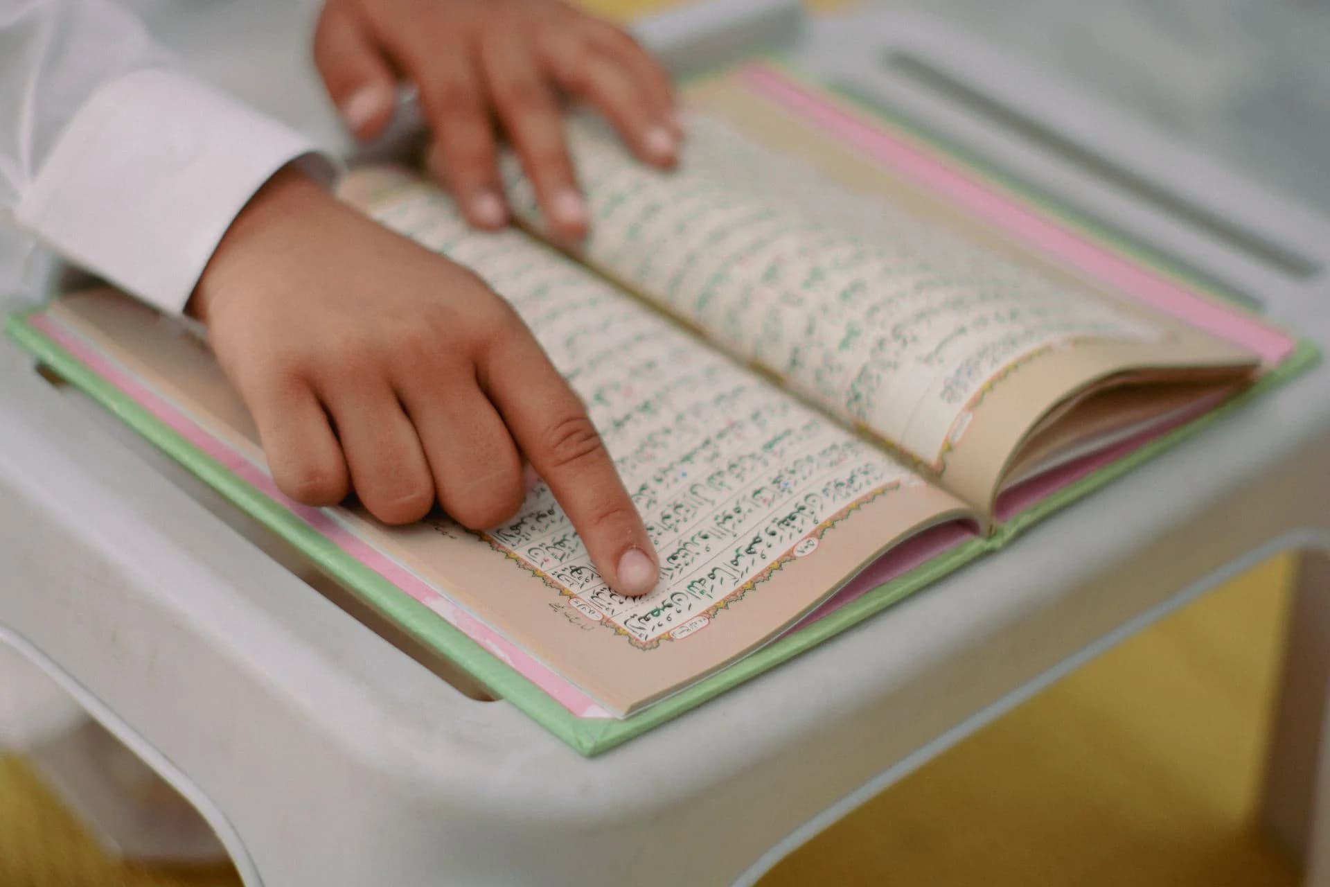 An open Quran resting beside a study lamp, representing focused Quranic learning